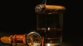 cigar a glass of whiskey and a watch